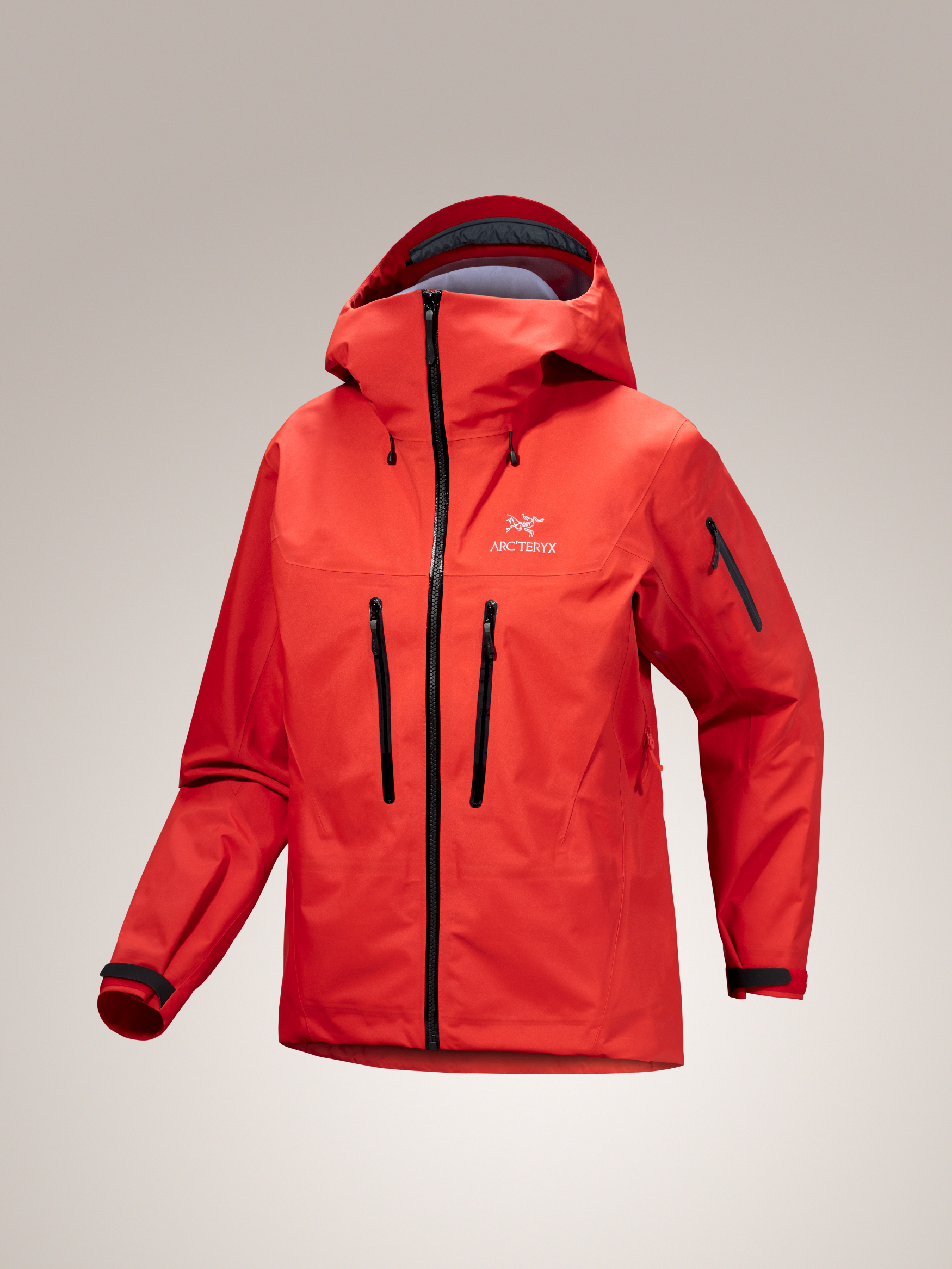 Red Arc'teryx Alpha SV jacket with black zippers on a gray background