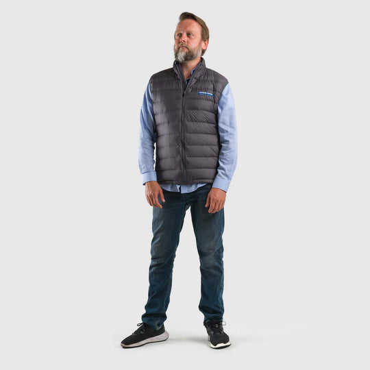 Studio front view of a man wearing a steel gray Men's Feathered Friends Eos Vest